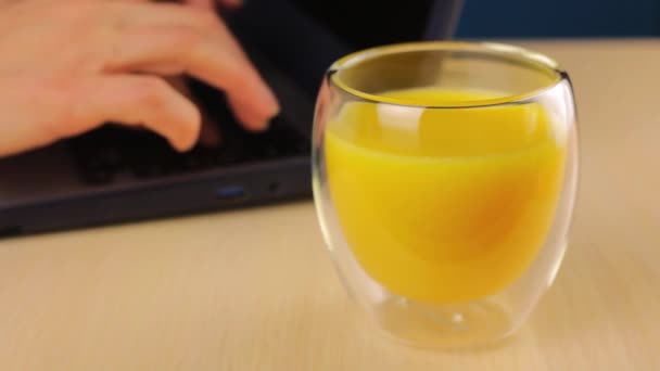 Vaso Con Zumo Naranja Primer Plano Mujer Trabaja Detrás Portátil — Vídeo de stock