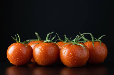 Siyah arka planda taze domatesler. Sağlıklı gıda konsepti.