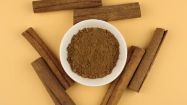 Gövdedeki tarçın tozu ve tarçın çubukları yavaşça dönüyor. Baharat üst görünümü.