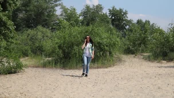 Жінка Йде Пісок Розмовляє Телефону Задньому Плані Зелені Дерева — стокове відео