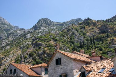 Dağlardaki eski Kotor Montenegro kasabası ve mavi gökyüzü arka planı. Yazın aydınlık ve güzel bir manzara açık bir günde.