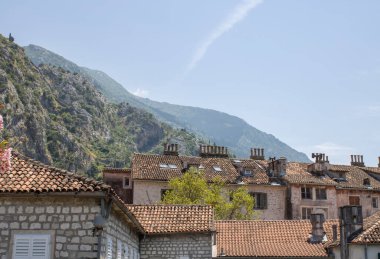 Dağlardaki eski Kotor Montenegro kasabası ve mavi gökyüzü arka planı. Yazın aydınlık ve güzel bir manzara açık bir günde.