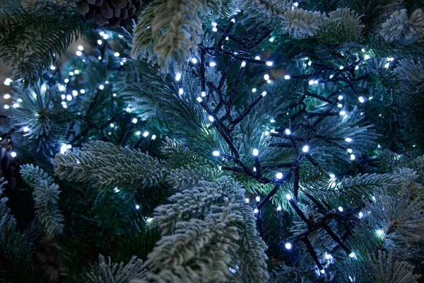  Yapay kar ve beyaz çelenklerle süslenmiş yapay Noel ağacı..