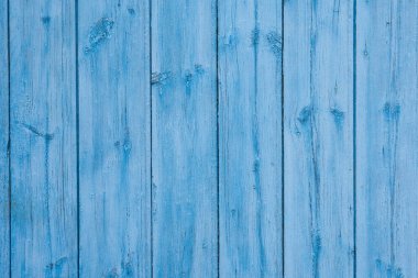 Hafif derin boyayla boyanmış ahşap tahtalar. Yakın çekim, ahşap taneciklerin üzerindeki çatlak boyanın dokusunu aktarıyor. Fotoğraf arka plan olarak mükemmel.