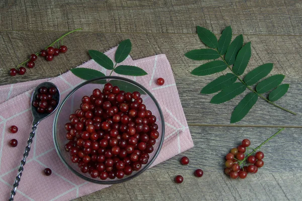Ahşap bir arka planda rowan çileği tabağı. Kahvaltı ya da tarif için düzen fikri