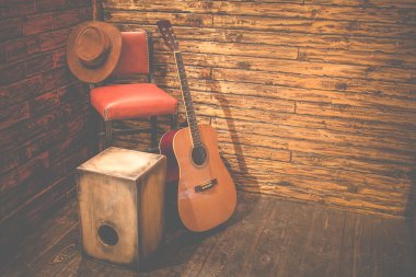 Cajon and acoustic guitar on wooden stage in pub clipart