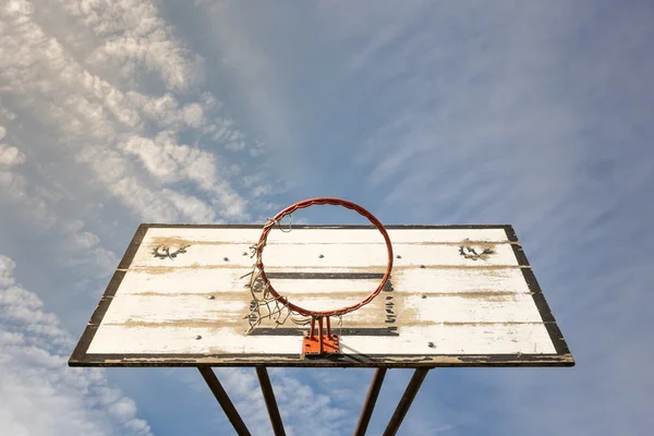 Παλιό καλάθι μπάσκετ του δρόμου με ένα θολό μπλε ουρανό — Φωτογραφία Αρχείου