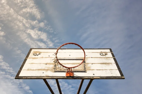 Vecchio cestino da basket di strada con un cielo blu nuvoloso — Foto Stock