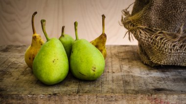 Ahşap masa üzerinde sarı ve yeşil armut 