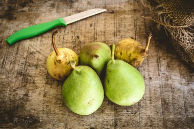 Ahşap masa üzerinde sarı ve yeşil armut 