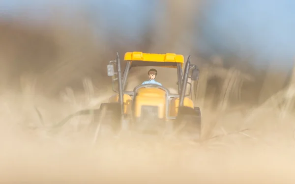 Small yellow toy tractor — Stock Photo, Image