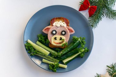 2021 'in yenilebilir boğa sembollü komik sandviçi. Ekmek, jambon, peynir ve zeytinden yapılmış. Çocuklar için Kahvaltı Fikri. Yılbaşı yemeği, bayram, Noel, yemek sanatı. Üst görünüm