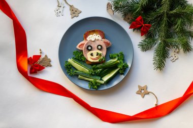 2021 'in yenilebilir boğa sembollü komik sandviçi. Ekmek, jambon, peynir ve zeytinden yapılmış. Çocuklar için Kahvaltı Fikri. Yılbaşı yemeği, bayram, Noel, yemek sanatı. Üst görünüm