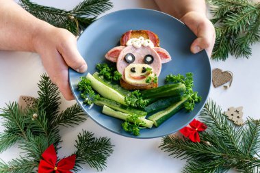 2021 'in yenilebilir boğa sembollü komik sandviçi. Ekmek, jambon, peynir ve zeytinden yapılmış. Çocuklar için Kahvaltı Fikri. Yılbaşı yemeği, bayram, Noel, yemek sanatı. Üst görünüm