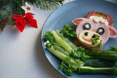2021 'in yenilebilir boğa sembollü komik sandviçi. Ekmek, jambon, peynir ve zeytinden yapılmış. Çocuklar için Kahvaltı Fikri. Yılbaşı yemeği, bayram, Noel, yemek sanatı. Yan görünüm. 