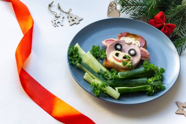 2021 'in yenilebilir boğa sembollü komik sandviçi. Ekmek, jambon, peynir ve zeytinden yapılmış. Çocuklar için Kahvaltı Fikri. Yılbaşı yemeği, bayram, Noel, yemek sanatı. Yan görünüm. 