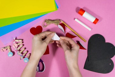 Sevgililer Günü. Aşıklar bayramı için tebeşir kalpli bir kartpostal hazırlamak için adım adım talimatlar. Diy konsepti. Dördüncü adım, kalpleri ortaya eğmek..