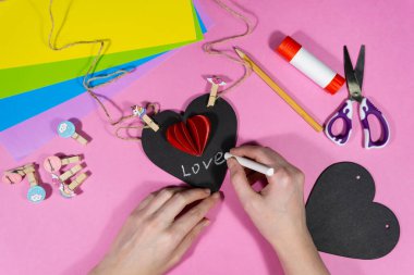 Sevgililer Günü. Aşıklar bayramı için tebeşir kalpli bir kartpostal hazırlamak için adım adım talimatlar. Diy konsepti. 9. adım Tebeşir kalbine tebeşirle yazı yazacağız..