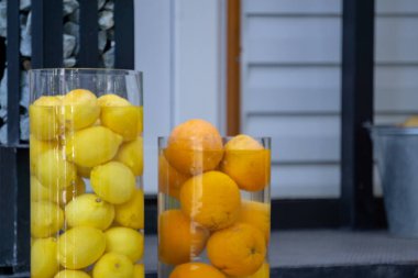 Bütün limon ve portakallar açık havada suyla dolu büyük bir vazoda yatıyor. Limon ve portakal arkaplanı.