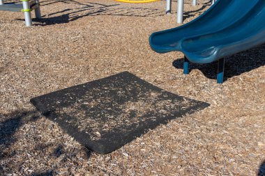 Kaydırağın yakınındaki oyun parkında lastik kaplama bölümü çocukların yaralanmasına engel oluyor.