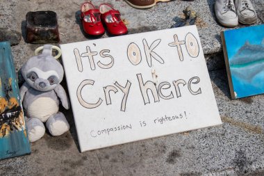 Vancouver, Canada - August 14,2021: Memorial for Indigenous children which remains have been found near the city of Kamloops in May. A view of sign Its ok to cry here in front of Vancouver Art Gallery clipart
