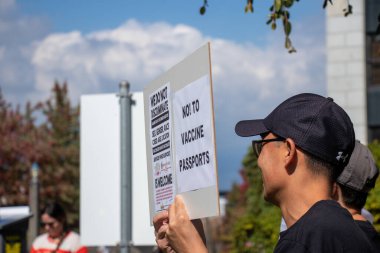 Vancouver, Kanada - 8 Eylül 2021: Vancouver Belediye Binası önündeki BC Aşı Kartı 'na karşı düzenlenen mitingde aşı pasaportlarına hayır işareti