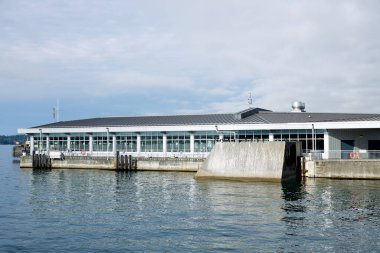 Vancouver, Kanada - 25 Eylül 2025: Lonsdale Quay, Kuzey Vancouver 'daki modern beyaz feribot terminali, büyük cam pencereler, sakin giriş sularının üzerinde beton rampa