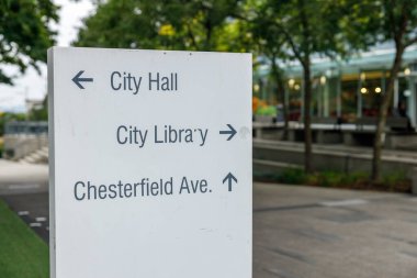 Kuzey Vancouver, Kanada - 25 Eylül 2025: Kuzey Vancouver 'da bilgilendirme amaçlı beyaz işaret Belediye Binasının solunda, Şehir Kütüphanesi sağda ve Chesterfield Bulvarı' nda