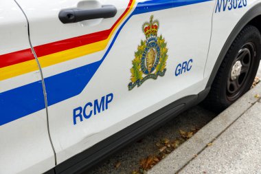 Kuzey Vancouver, Kanada - 25 Şubat 2025: Iconic Royal Canada atlı polis devriye aracı tarafı renkli çizgiler, taç ve bizon amblemi, iki dilli RCMP GRC beyaz SUV kapısı üzerinde metin