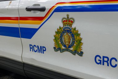 Kuzey Vancouver, Kanada - 25 Şubat 2025: Iconic Royal Canada atlı polis devriye aracı tarafı renkli çizgiler, taç ve bizon amblemi, iki dilli RCMP GRC beyaz SUV kapısı üzerinde metin
