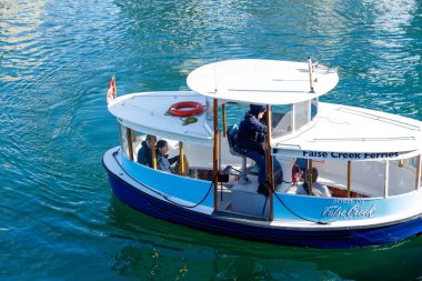 Vancouver, Kanada - 6 Ekim 2025 False Creek Ferries Spirit of False Creek yolcu botu beyaz tepe örtüsü, mavi gövde ve turkuaz su üzerinde seyreden sarı bukle