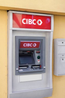 Vancouver, Kanada - 6 Ekim 2025: Granville Adası 'ndaki beyaz güvenlik paneli ile sarı duvarda kırmızı logoya monte edilmiş CIBC banka ATM makinesi