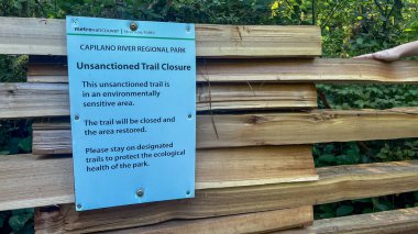 Vancouver, Kanada - 23 Ağustos 2025: Mavi Metro Vancouver tabelası Capilano Nehri Bölge Parkı 'nda çevresel restorasyon için izinsiz kapanma duyurusu yapıyor