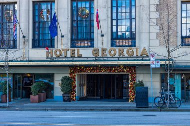 Vancouver, Kanada - 17 Aralık 2025: Noel süslemeleri, eyalet ve Kanada bayrakları ile Gürcistan Oteli girişi, tarihi Vancouver şehir merkezi