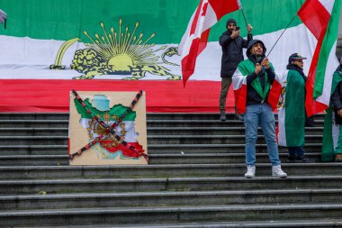 Vancouver, Kanada - 10 Ocak 2026: Büyük İran aslanı ve güneş bayrağı Vancouver Sanat Galerisi basamaklarında muhalefet posteriyle protesto mitinginde sergilendi