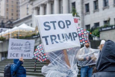 Vancouver, Kanada - 10 Ocak 2026: Vancouver Sanat Galerisi mitinginde düzenlenen plastik yağmur korumalı Trump protesto tabelasını durdurun