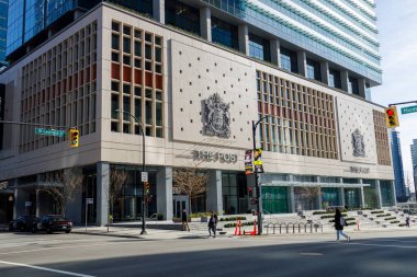 Vancouver, Kanada - 2 Mart 2026: Batı Georgia Caddesi 'ndeki Post binasında İngiliz arması, perakende tabanının üzerinde modern cam kuleler yer alıyor