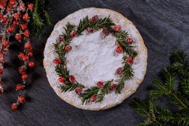 Kızılcık ve çam dallarıyla süslenmiş şenlikli bir pasta ile yeni yıl. Tatil kavramı.