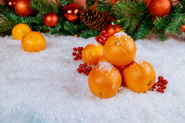 Organik portakallar beyaz karla süslenmiş noel süsleri. Sağlıklı gıda konsepti.
