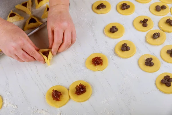 Making hamentaschen cookies with jam for Purim. Jewish holiday concept,