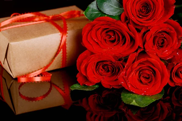 Geschenk Mit Roter Schleife Und Einem Strauß Schöner Roter Rosen — Stockfoto