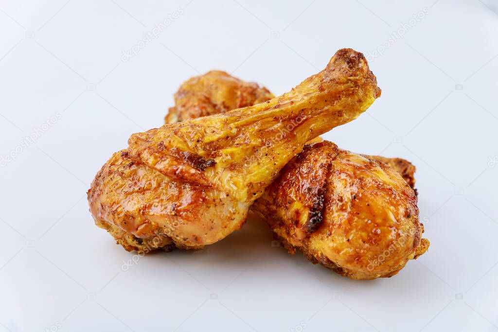 Grilled chicken drumsticks marinated with buffalo sauce isolated on white background. Close up.