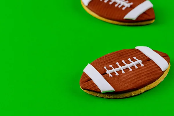 緑の背景にラグビーボールクッキー アメリカンフットボールの背景 — ストック写真