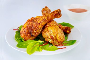 Beyaz tabakta ıspanaklı baharatlı tavuk budu..