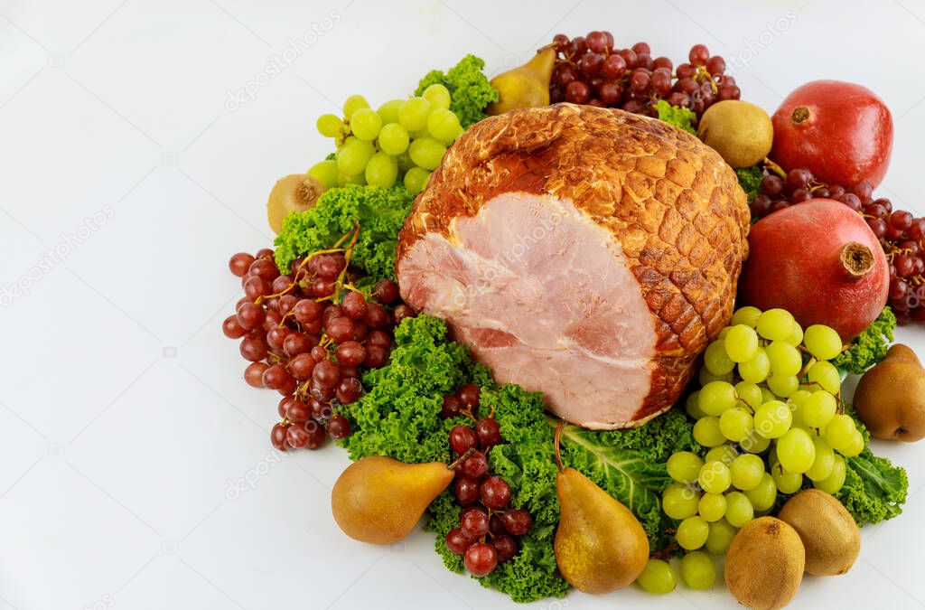 Boneless whole pork ham with fresh fruits. Healthy food. Easter meal.