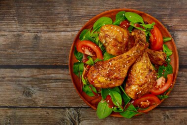 Kırsal ahşap arka planda salatalı kızarmış tavuk budu. Üst Manzara. Boşluğu kopyala.