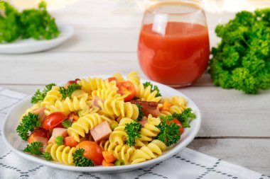 İtalyan makarnası, jambon ve sebze ve bir bardak domates suyu. Dengeli yemek..