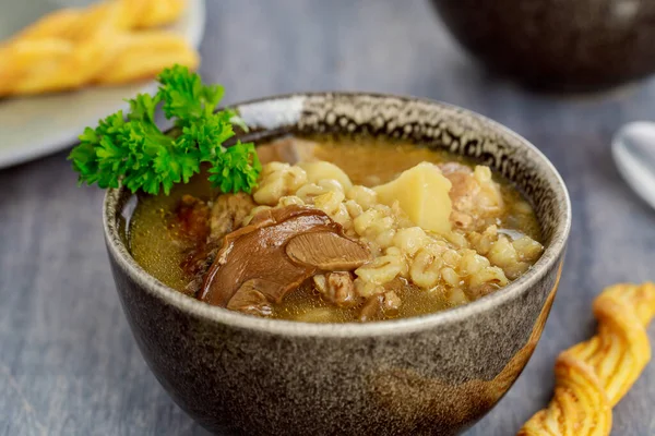 Pearl barley soup with mushrooms and potato. Close up.