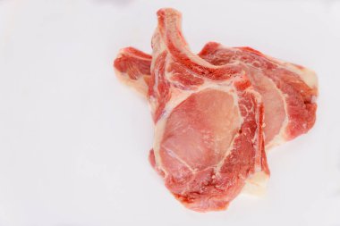 Beyaz arka planda çiğ domuz pirzolası kemiği. Üst görünüm.