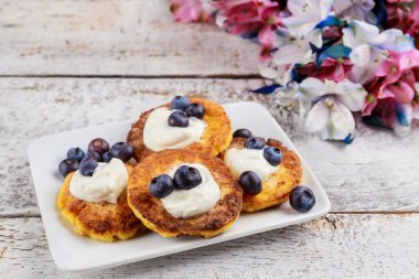Ekşi krema ve taze yaban mersinli süzme peynirden yapılmış krepler. Kapat..